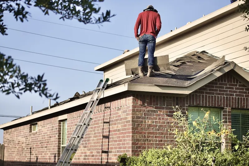 Professional roofer working on a residential roof in John T. White